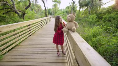 Dost canlısı bir çocuk Florida 'da parkta oyuncak ayısı arkadaşıyla dedikodu yapıyor. Arkadaşlık kavramı.