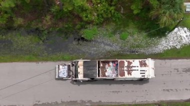 Yerleşim bölgesinde çöp temizleme. Atık kamyonlar banliyö sokaklarında sürerken çöpleri yüklüyorlar