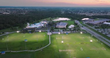 Kuzey Port, Florida 'da halk spor sahasında gün batımında çimen futbol stadyumunda futbol oynayan insanlarla aydınlandı. Açık hava aktiviteleri konsepti.