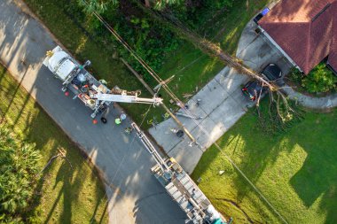 Florida 'da kasırga sonrası. İşçiler evdeki elektrik kablolarını tamir etmek için kova kamyonları kullanıyorlar. Kamu hizmetleri hasar gören elektrik hatlarını tamir ediyor.