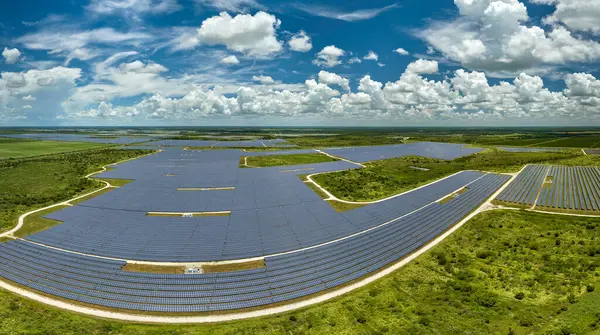 Temiz elektrik enerjisi üretmek için sıra sıra güneş fotovoltaik panelleri olan sürdürülebilir büyük elektrik santralinin havadan görünüşü. Sıfır emisyonlu yenilenebilir elektrik kavramı.