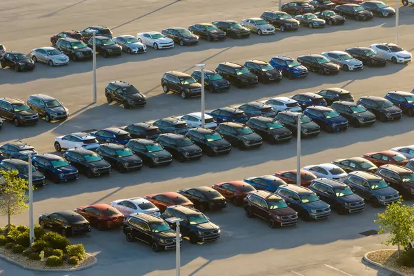 Satıcıların açık hava otoparkından bir sürü yeni araba satışa sunuluyor. Amerikan otomotiv endüstrisinin gelişimi kavramı.