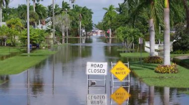 Su uyarı levhasının altındaki sokak. Su baskını yüzünden kapalı şehir yolu araba kullanmasını engelliyor. Punta Gorda, Florida 'da Milton Kasırgası.