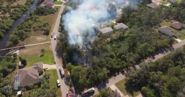 Florida 'daki evlerin yakınlarındaki yangında itfaiye araçları ve acil durum ekibi alevlerle mücadele ediyor..