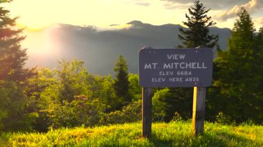 Kuzey Carolina Appalachian dağlarındaki Blue Ridge Parkway 'de araba yolculuğu. Mitchell Dağı Overlook yaz mevsiminde gün batımında. Güzel doğanın yaz manzarası.