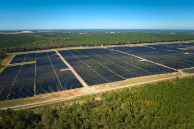 Temiz elektrik enerjisi üretmek için birçok sıra güneş fotovoltaik paneli bulunan sürdürülebilir büyük elektrik santralinin havadan görünüşü. Sıfır emisyon kavramı ile yenilenebilir elektrik.