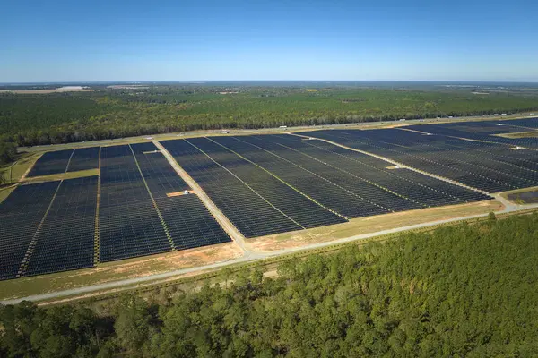 Temiz elektrik enerjisi üretmek için birçok sıra güneş fotovoltaik paneli bulunan sürdürülebilir büyük elektrik santralinin havadan görünüşü. Sıfır emisyon kavramı ile yenilenebilir elektrik.