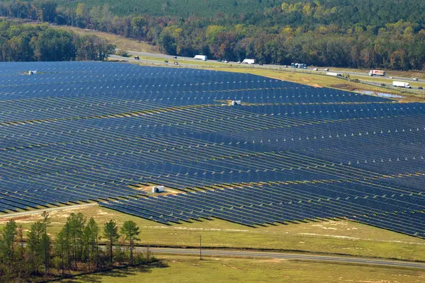 Temiz elektrik enerjisi üretmek için sıra sıra güneş fotovoltaik panelleri olan sürdürülebilir büyük elektrik santralinin havadan görünüşü. Sıfır emisyonlu yenilenebilir elektrik kavramı.