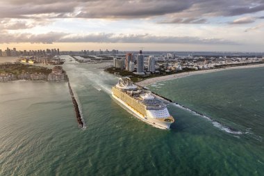 Güney Sahili yakınlarındaki Miami limanı ana kanalından ayrılan bir yolcu gemisi. Sahildeki lüks oteller ve apartmanlar ve şehir merkezindeki yüksek gökdelenler..