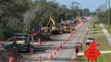 Florida 'da inşaat halinde. Kazı makineleri, koniler ve uyarı levhaları var. Arabalar siper kazma işini ve engelleri yavaş yavaş aşıyor