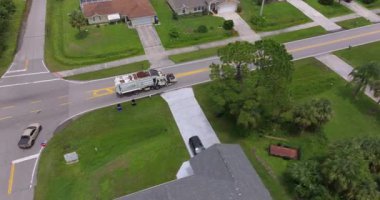 Çöp kamyonu Amerikan mahallesinin kaldırımından çöp kutusu yüklüyor.