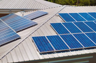 Temiz ekolojik elektrik enerjisi üretmek için mavi güneş fotovoltaik panelleri olan ev çatısı. Emeklilik geliri için yenilenebilir elektriğe yatırım.