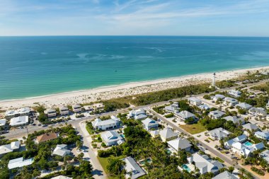 Varlıklı sahil manzaralı bir yer. Meksika Körfezi kıyısındaki yeşil palmiye ağaçları arasında pahalı malikaneler. Gasparilla Adası 'ndaki küçük Boca Grande kasabası..