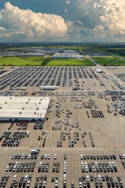 Otomotiv endüstrisi. Üretim fabrikası deposuna yeni araba ithal veya ihracatı. Lojistik sektörü otoparkında satılık araçlar.