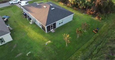 Florida 'da bahçıvan bakımı. Bahçede çim biçen işçiler sıfır dönüşlü çim taşıyıcı traktörüyle