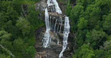 Nantahala Ulusal Ormanı 'ndaki kayalık kayaların arasına temiz su dökülen büyük şelaledeki orman sularıyla muhteşem bir yaz manzarası. Whitewater Şelalesi, Kuzey Carolina, ABD.