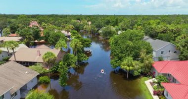 Debby Kasırgası, Sarasota, Florida 'da sokağı sular altında bıraktı. Yerleşim bölgelerindeki kırsal evler arasındaki sel sularında kano kullanan kurbanlar