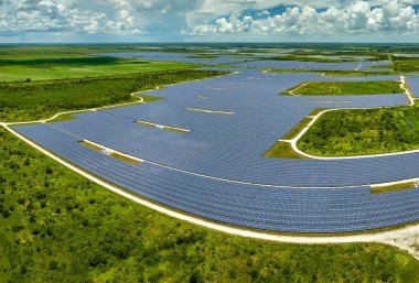 Temiz elektrik enerjisi üretmek için birçok sıra güneş fotovoltaik paneli bulunan sürdürülebilir büyük elektrik santralinin havadan görünüşü. Sıfır emisyon kavramı ile yenilenebilir elektrik.