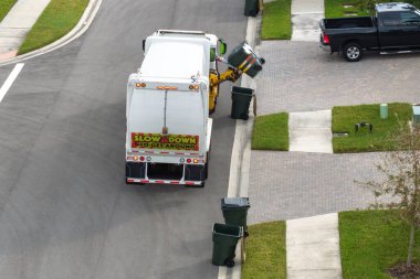 Otomatik modern çöp kamyonu Florida şehir caddesinde atık yüklüyor. Belediye hizmetleri.