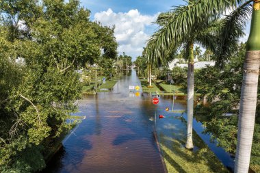 Florida 'da kasırga sonrası caddeyi su basmış. Kapalı levhalar araba sürmeyi engelliyor. Doğal afet konsepti sırasında ulaşımın güvenliği.
