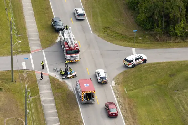 Florida 'daki bisikletçi kazasına ilk müdahale ekipleri gelmiş. Kurban sedyede. Acil servis, ABD 'de şehir caddesinde trafik kazası geçiren bir adama yardım ediyor..