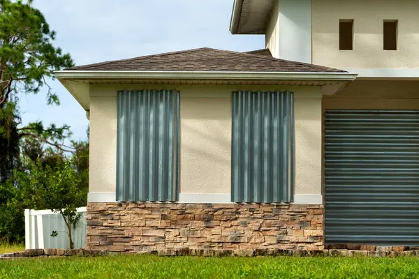 Kasırga koruması için güçlendirilmiş fırtına kepenkleri olan Florida 'daki bir ev. Felakete hazırlık olarak pencere örtüsü.