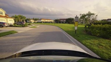 Araba sürücüsü. Ulaşım ve trafik kavramı. Florida yerleşim bölgesindeki apartmanlar arasında banliyö caddesinde araç sürüyor.