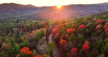 Kuzey Carolina 'daki huzurlu dağ yolu günbatımında en yüksek mevsimde. Appalachian manzarası canlı sonbahar renkleriyle dolu.