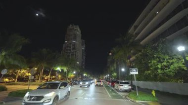 Gece Miami Beach sokaklarında devriye arabası sürüyormuş. Florida turistik bölgesinin güney mimarisi arasındaki Kentsel Amerikan Bulvarı