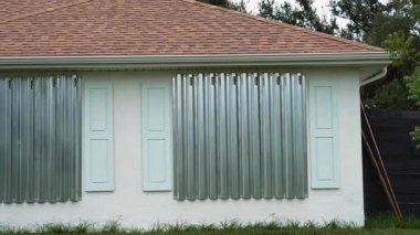 Kasırganın ev pencerelerini koruması için çelik çarşaflar, fırtına kepenkleri olarak monte edildi. Florida 'daki doğal felaketten önce koruyucu tedbirler.