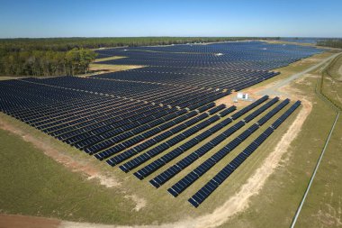 Temiz elektrik enerjisi üretmek için sıra sıra güneş fotovoltaik panelleri olan sürdürülebilir büyük elektrik santralinin havadan görünüşü. Sıfır emisyonlu yenilenebilir elektrik kavramı.