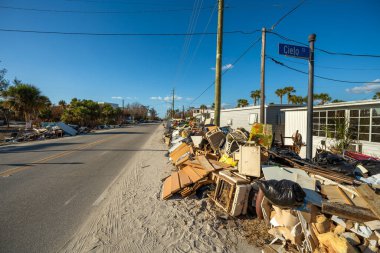 Hurda ve hurda, Florida 'daki ev alanındaki şiddetli hasar gören evlerden sonra sokak kenarındaki yığınlar halinde imha edildi. Doğal afetin sonuçları..