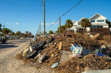 Florida 'daki kasırgadan sonra temizlik çalışmaları. Manasota Key 'in kırılan mobilya yığınları, ev enkazı ve inşaat atığı caddeleri, yerel evler ve altyapı üzerinde ciddi bir etki gösteriyor..