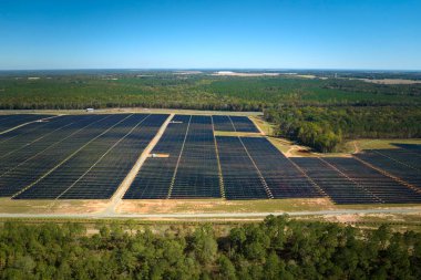 Temiz elektrik enerjisi üretmek için sıra sıra güneş fotovoltaik panelleri olan sürdürülebilir büyük elektrik santralinin havadan görünüşü. Sıfır emisyonlu yenilenebilir elektrik kavramı.