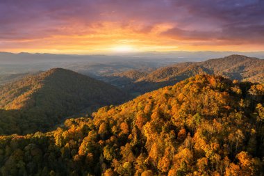 Günbatımında Appalachian dağlarının sonbahar ormanları. Renkli ormanlarda sarı ve turuncu gölgeler. Sonbahar mevsiminde vahşi doğanın manzarası.