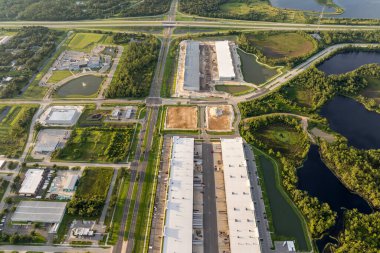 Beton ve metal çerçeve duvarları birleştirilmiş lojistik merkezinin inşaat alanı. Ticari yapının büyük gelişim alanının havadan görünümü.