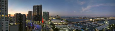 Brickell 'in yüksek aydınlık gökdelenleri, finans merkezi. Bayside Pazarı 'ndaki Miami Gözlem Çarkı' nda gece Biscayne Körfezi suyu ve ABD şehir manzarası yansımaları görülüyor..
