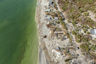 Yıkıma ya da onarıma ihtiyacı olan yıkılmış binalar. Fırtına dalgası suları dalgalandırdı ve rüzgâr evlerin çatılarını tahrip etti ve Florida 'da kasırga üstüne duvarlar çöktü..