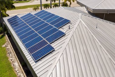 Banliyö bölgesinde temiz ekolojik elektrik üretimi için özel evin güneş çatısı fotovoltaik panellerle kaplı. Enerji tasarrufu için özerk eve yatırım yapma kavramı.