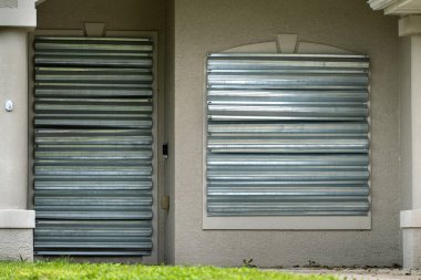 Kasırga hasarından korunmak için Florida 'daki evin camlarına çelik paneller monte edilmiş. Fırtına hazırlığı ve ev koruması.