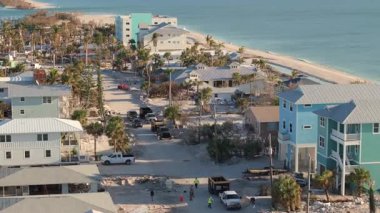 Milton Kasırgası temizlik sonrası. İşçiler, Florida 'da Manasota Key caddesinde enkaz ve kum yığınları topluyorlar.