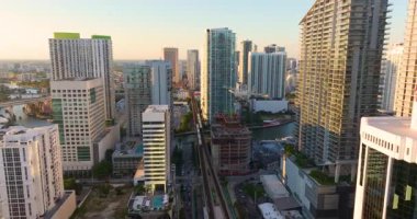 Toplu taşıma hatları için kentsel demiryolu ABD 'nin Florida kentindeki Miami Brickell şehir merkezine kadar uzanıyor. Şehrin yüksek binalarına ve tren güzergahına güneş ışığı vuruyor
