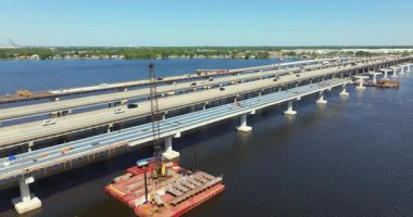 Aerial view of American highway bridge road under construction. Adding new lanes to bridge crossing Manatee River in Ellenton. Development of traffic infrastructure