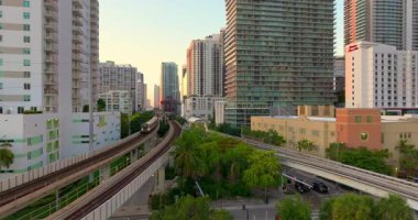 Miami, Florida, ABD 'nin modern şehir merkezinden geçen tren raylarının hava görüntüsü. Altın saatinde demiryolu üzerinde yüksek binalar