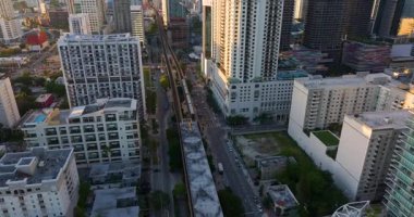 Miami, Florida 'daki Brickell bölgesinde yükseltilmiş tren sistemi. Şehir gökdelenleri ve günbatımı gökyüzü toplu taşıma ağını aydınlatıyor.