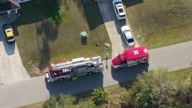 Emergency medical team responds to health incident at residential house with fire truck and ambulance on site