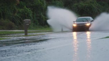 Amerikan caddesini, Florida yerleşim bölgesinde suyla çevrili hareket halindeki araçlarla doldurdu. Kasırga doğal felaketinin sonuçları.