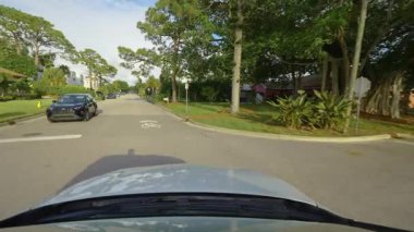 Venice, Florida yerleşim bölgesinde özel evler arasında Amerikan banliyö caddesinde araba sürüyor.