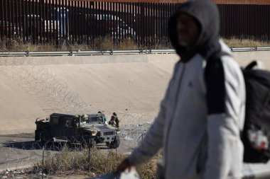 Juarez, Mexico, 12-21-2022: hundreds of migrants wait in front of the wall to be able to turn themselves in to the border patrol in American territory, to request humanitarian asylum.