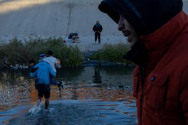 Juarez, Mexico, 12-21-2022: hundreds of migrants wait in front of the wall to be able to turn themselves in to the border patrol in American territory, to request humanitarian asylum.